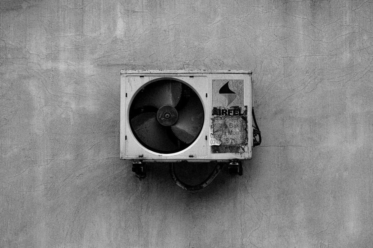 Unité extérieure de climatiseur fixée sur un mur en béton, photo en noir et blanc