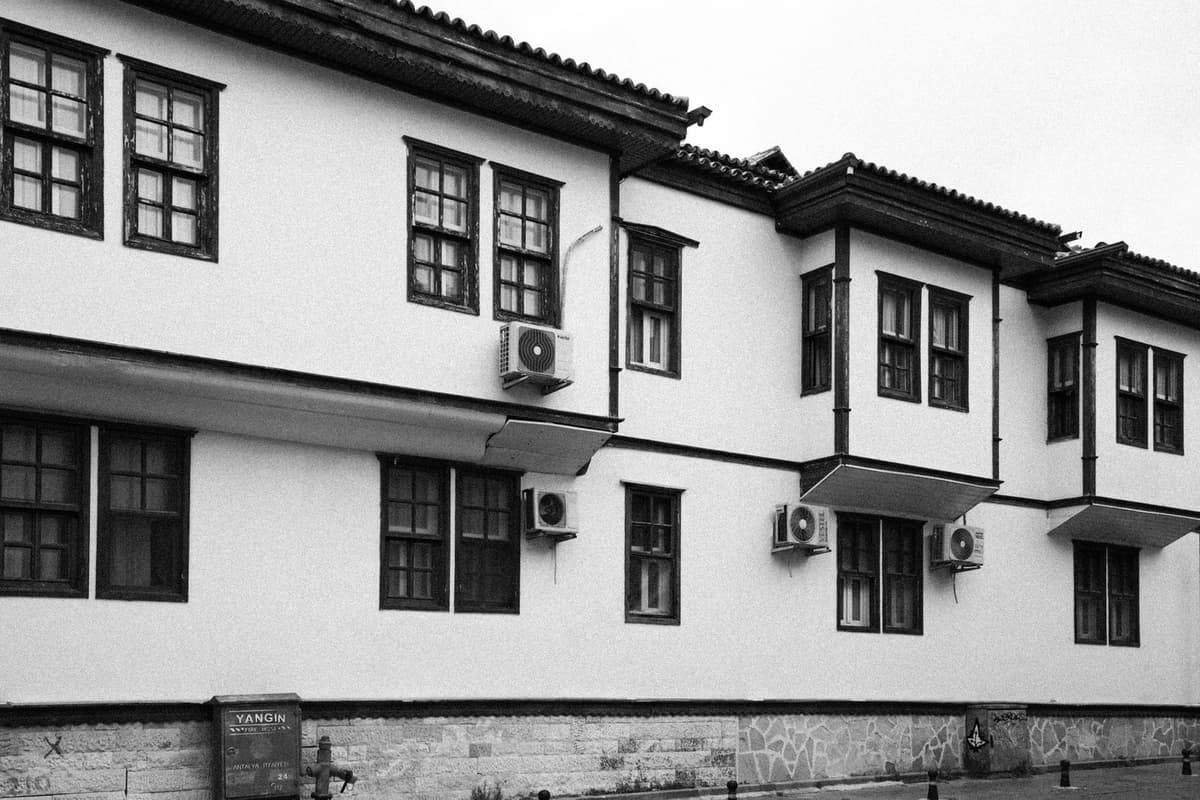 Unità esterne di condizionatori fissate sulla facciata bianca di un edificio a più piani, fotografia in bianco e nero