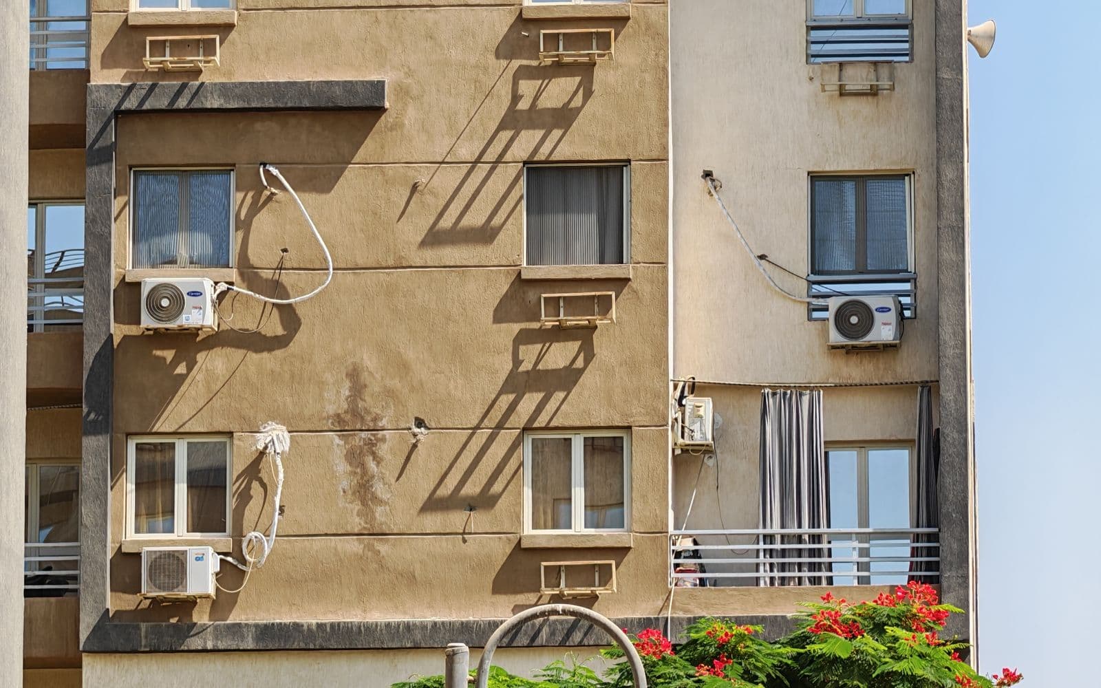 Air conditioning units on a city building under a clear summer sky