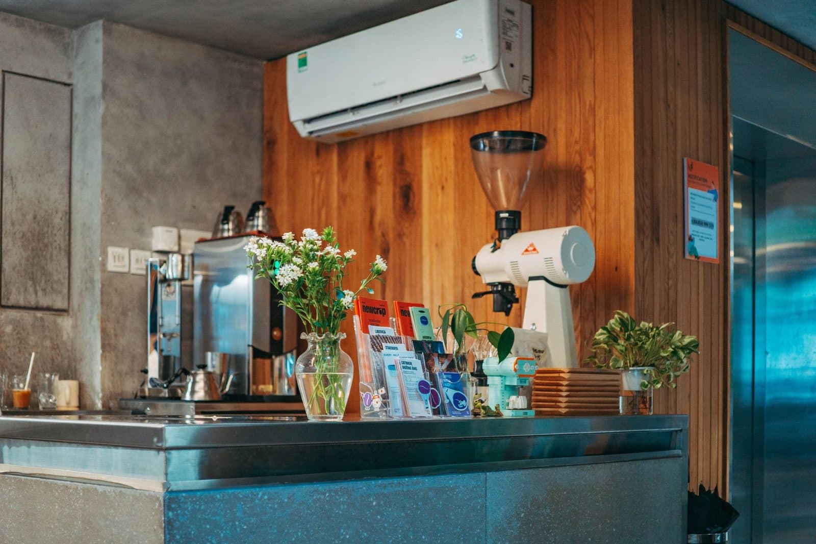 Witte split-wandairco boven een aanrecht van hout en metaal met koffiezetapparaat
