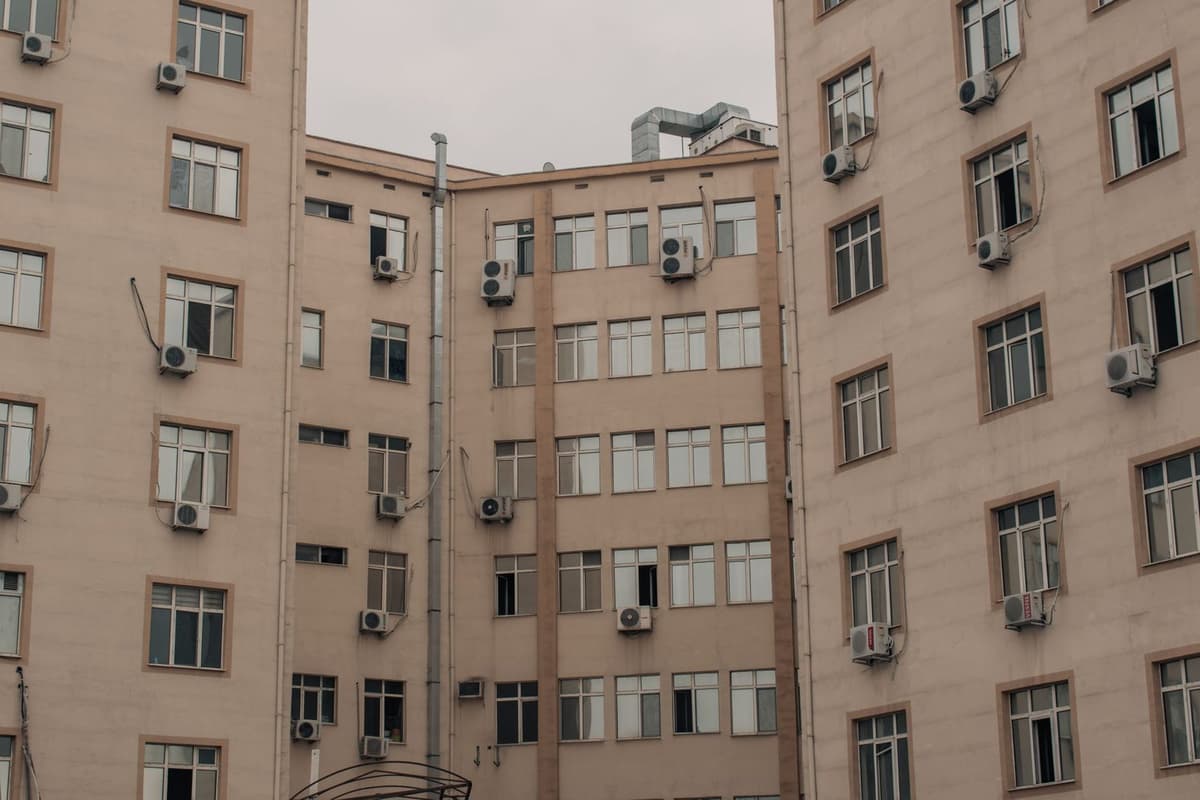 Unités extérieures de climatiseurs fixées sur la façade d'un immeuble d'habitation avec fenêtres