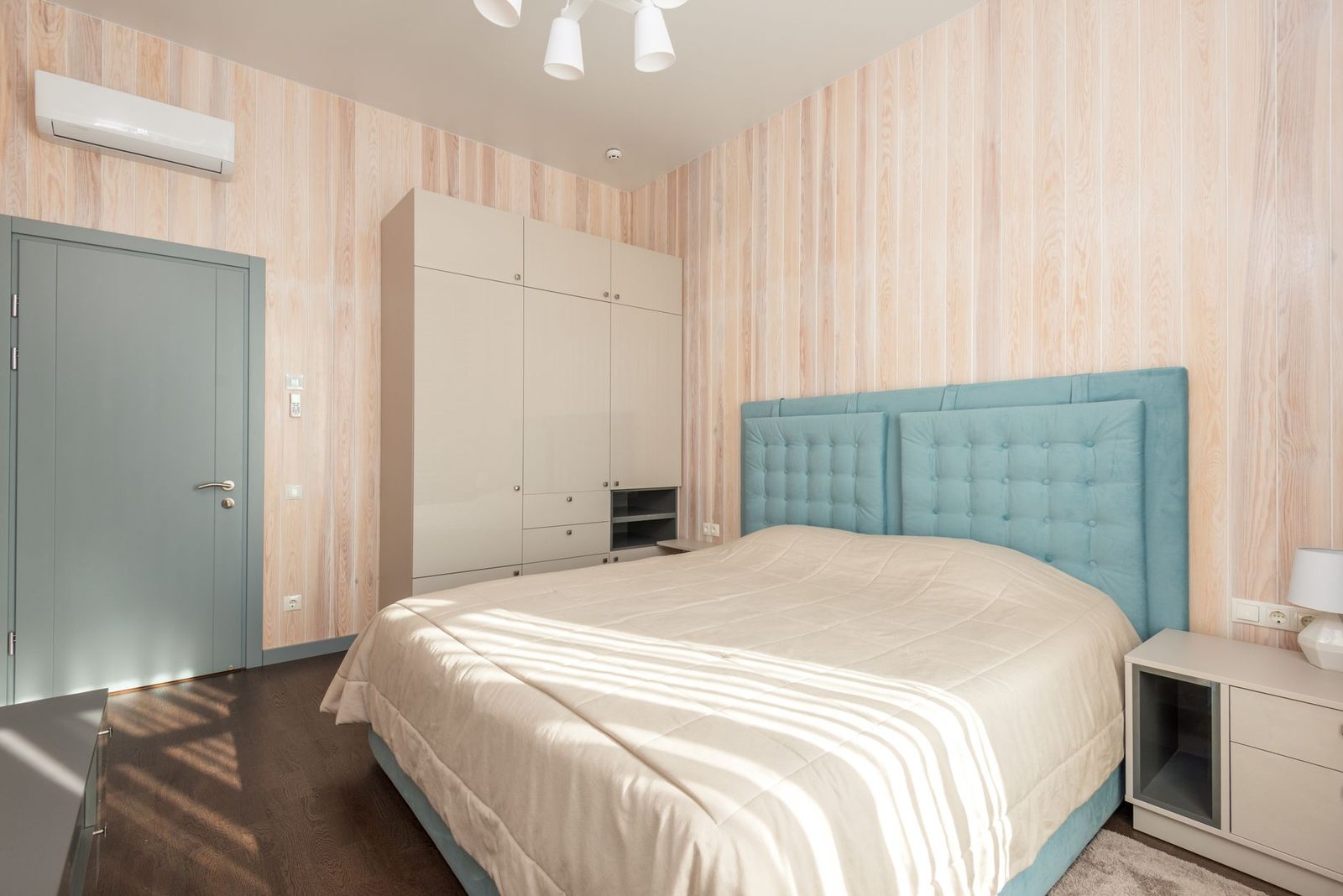 Unidade mural de ar condicionado reversível instalada num quarto com cama e roupeiro