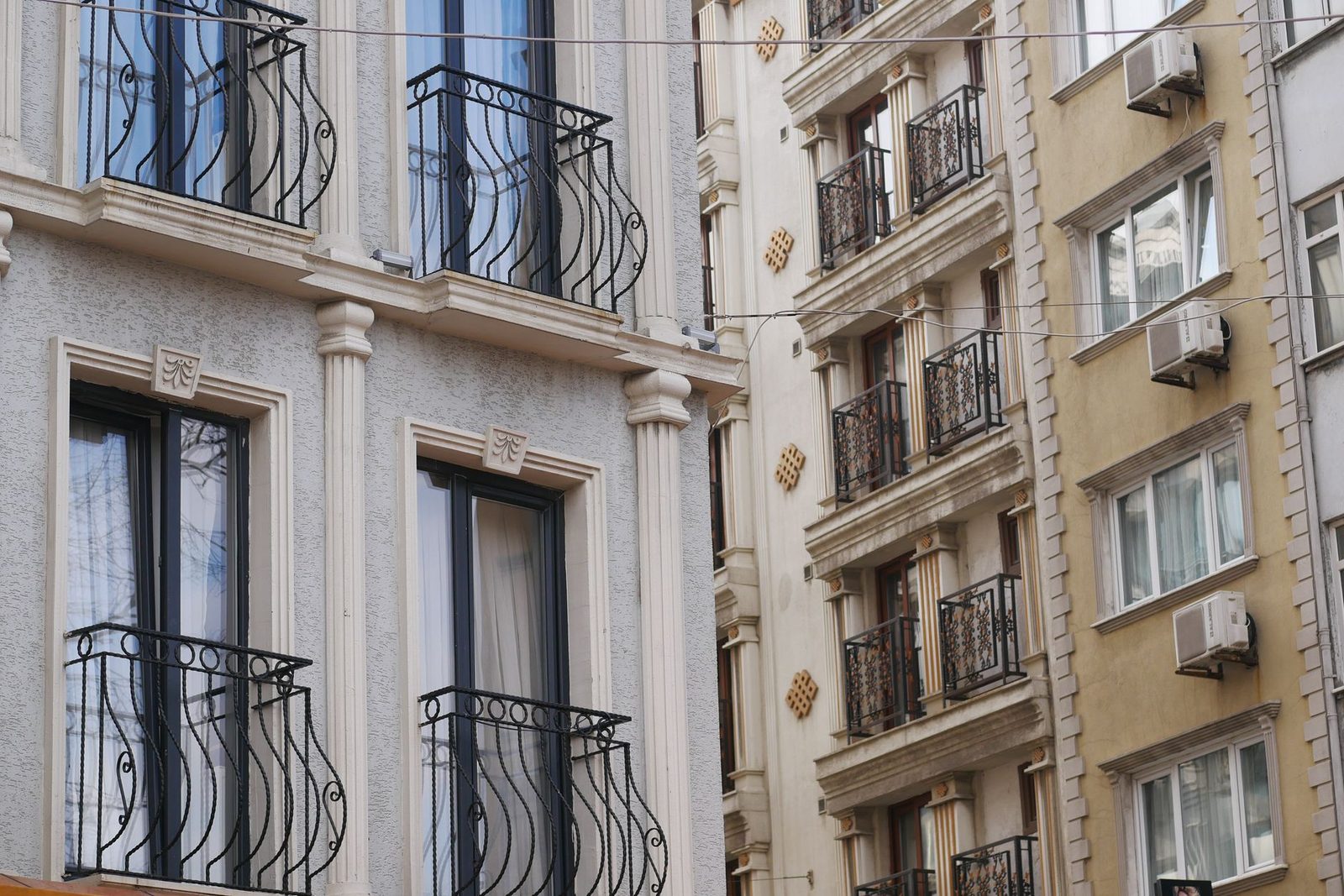 Unités extérieures de climatisation fixées sur les façades d'immeubles anciens avec balcons en fer forgé