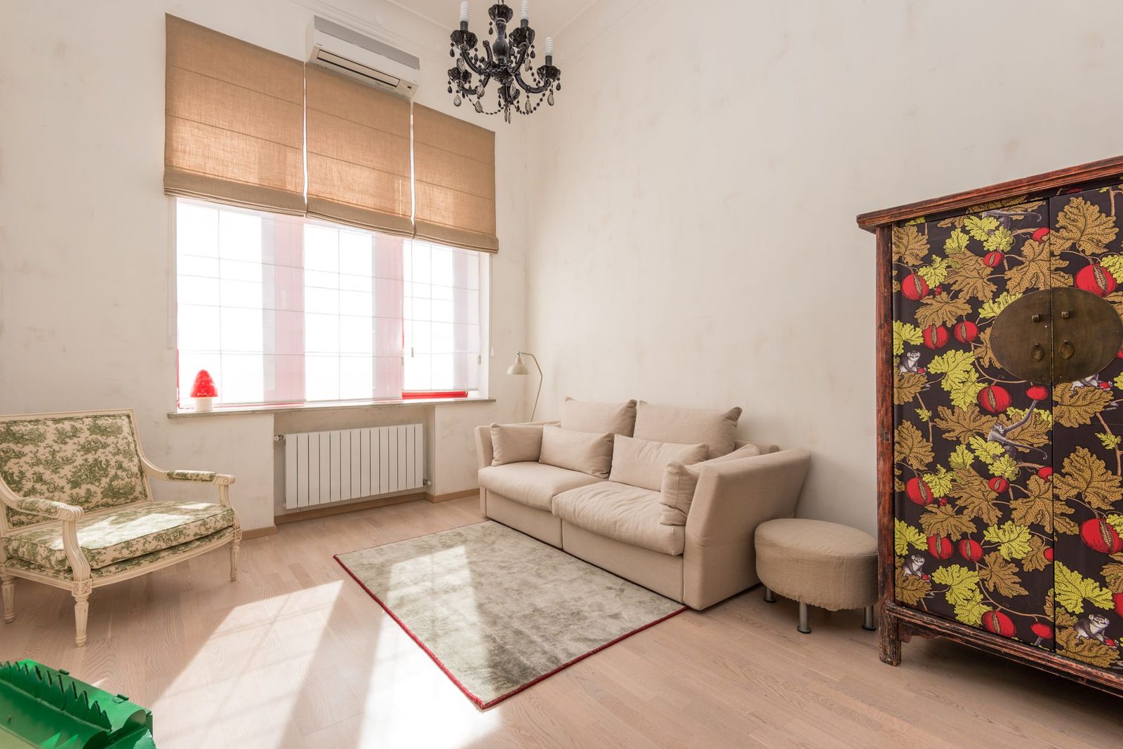Wandairco geïnstalleerd boven het raam van een lichte woonkamer met beige bank en radiator