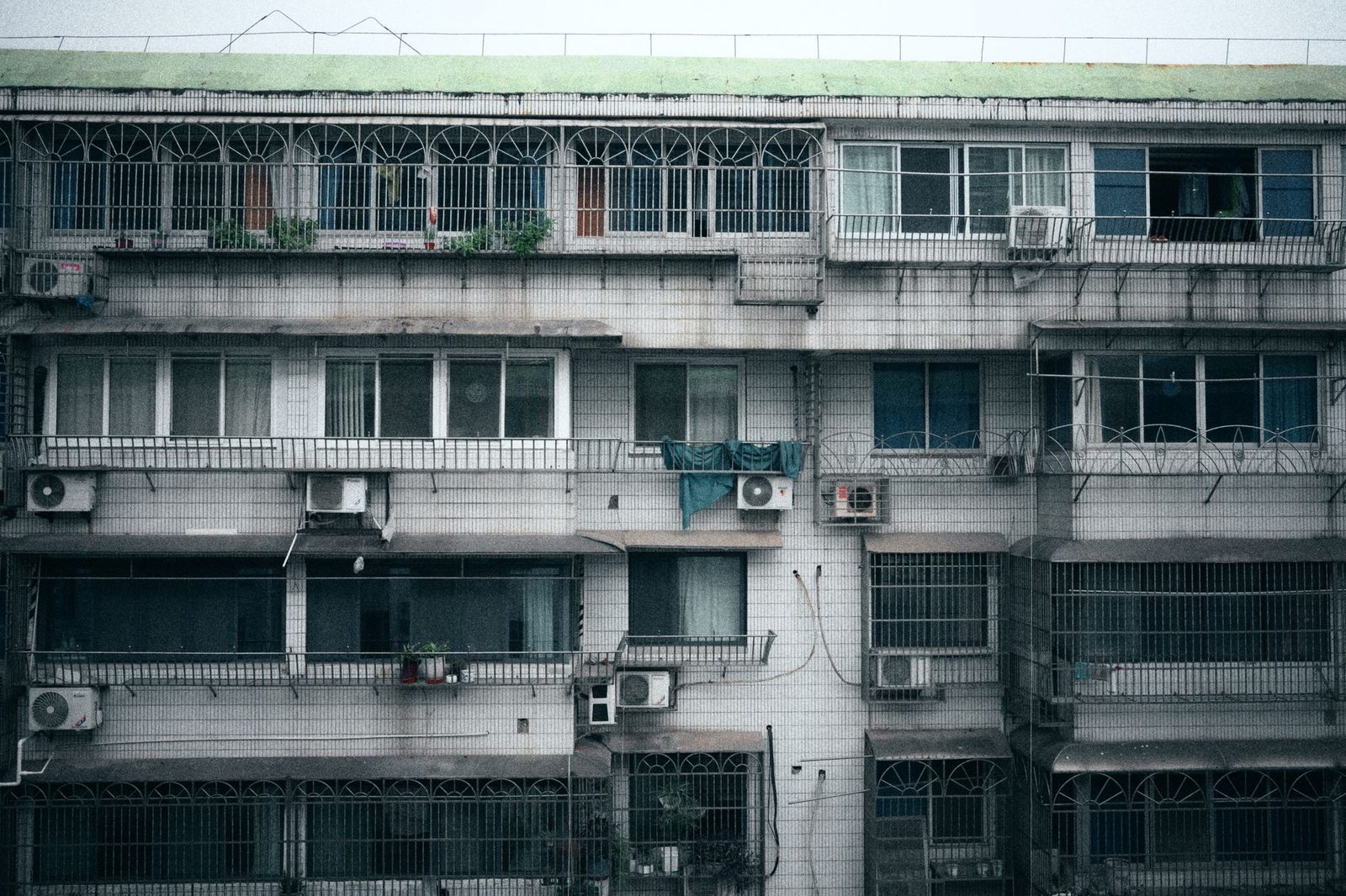 Façade d'un immeuble avec plusieurs unités extérieures de pompes à chaleur air-air installées aux murs.